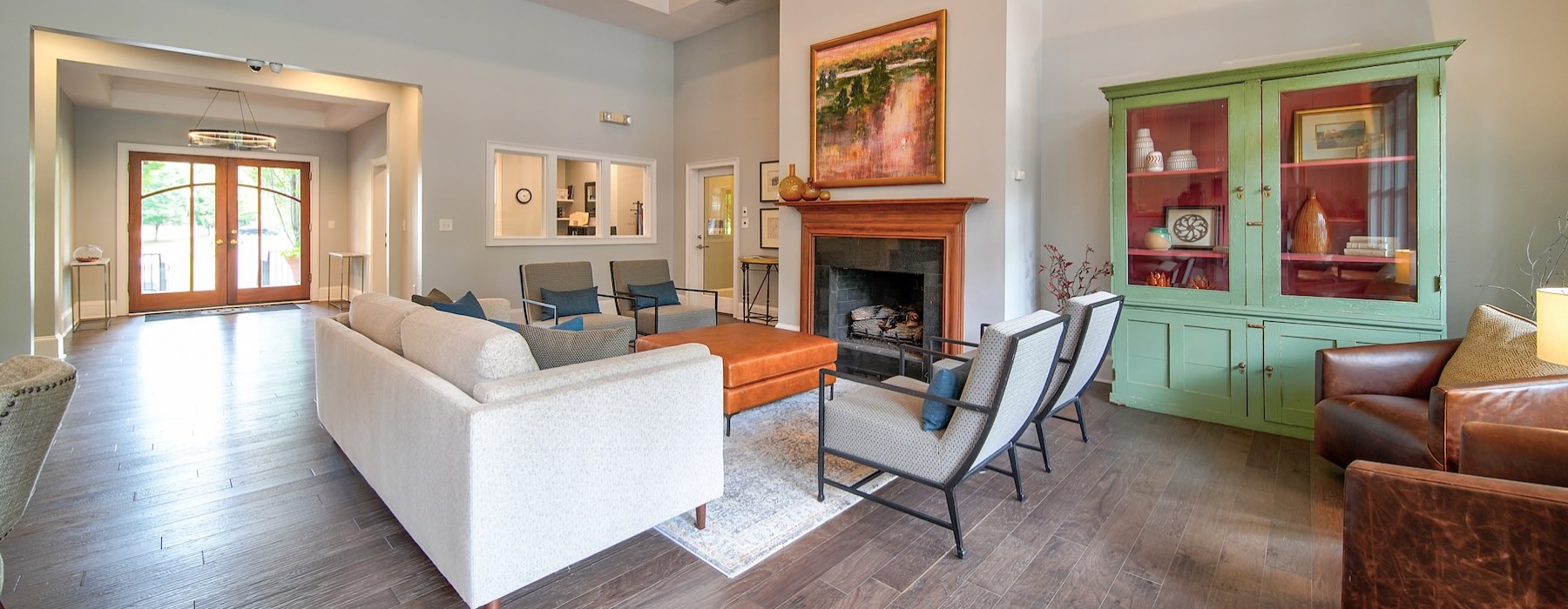 a clubroom with a couch, fireplace and chairs