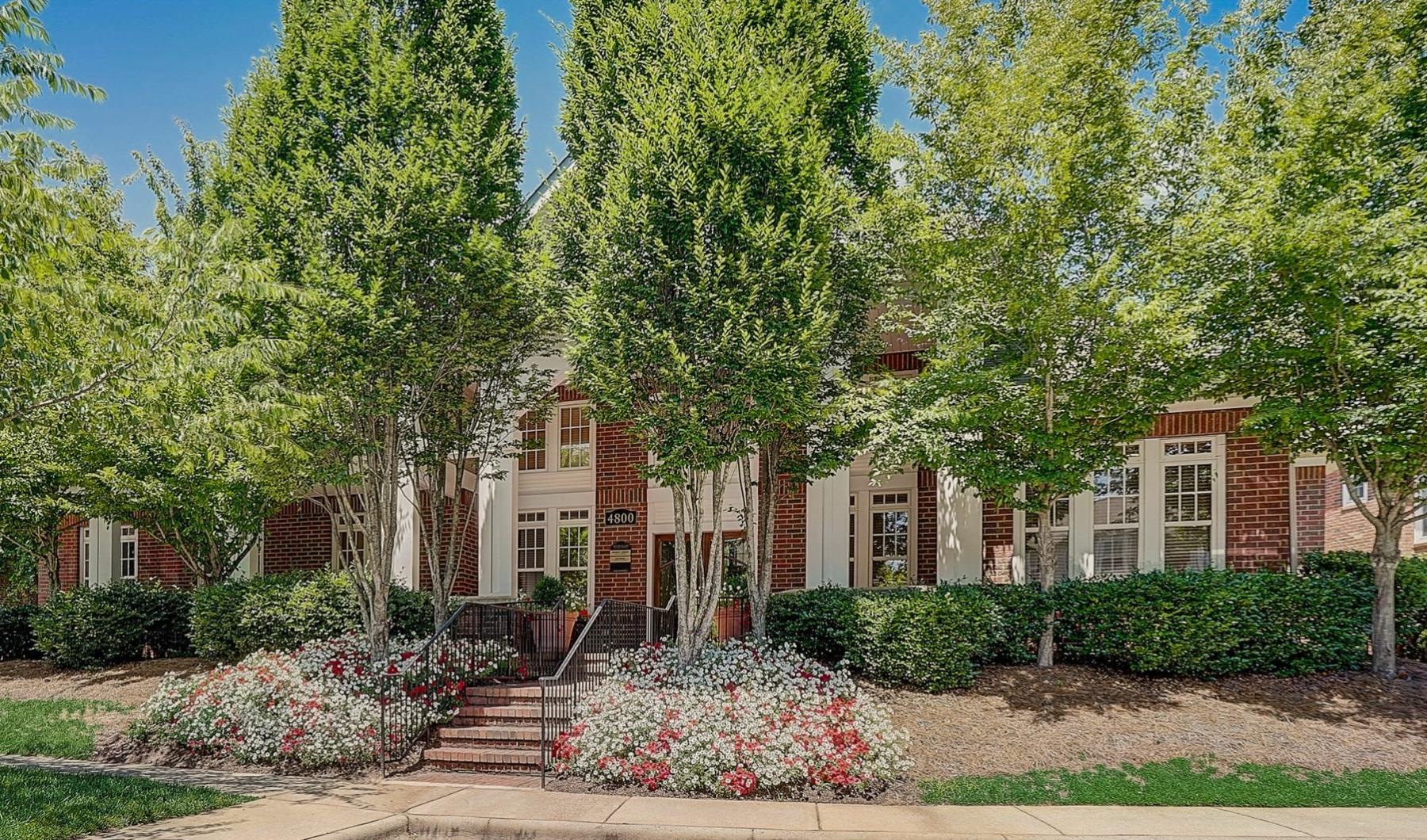 a building with trees and bushes in front of it